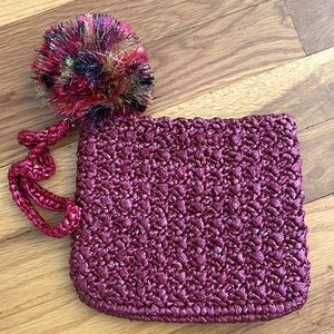 Woven straw wristlet with pom-pom in brick red